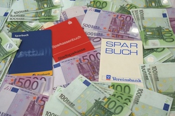 Das Bild zeigt Sparbücher und Geld.